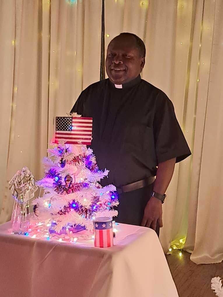 Father Boniface Kasiita Nzabonimpa — pastor of St. Boniface Parish in Brunswick, St. Joseph Parish in Salisbury and St. Mary of the Angels Parish in Wien — celebrates becoming a U.S. citizen, during a Christmas party.